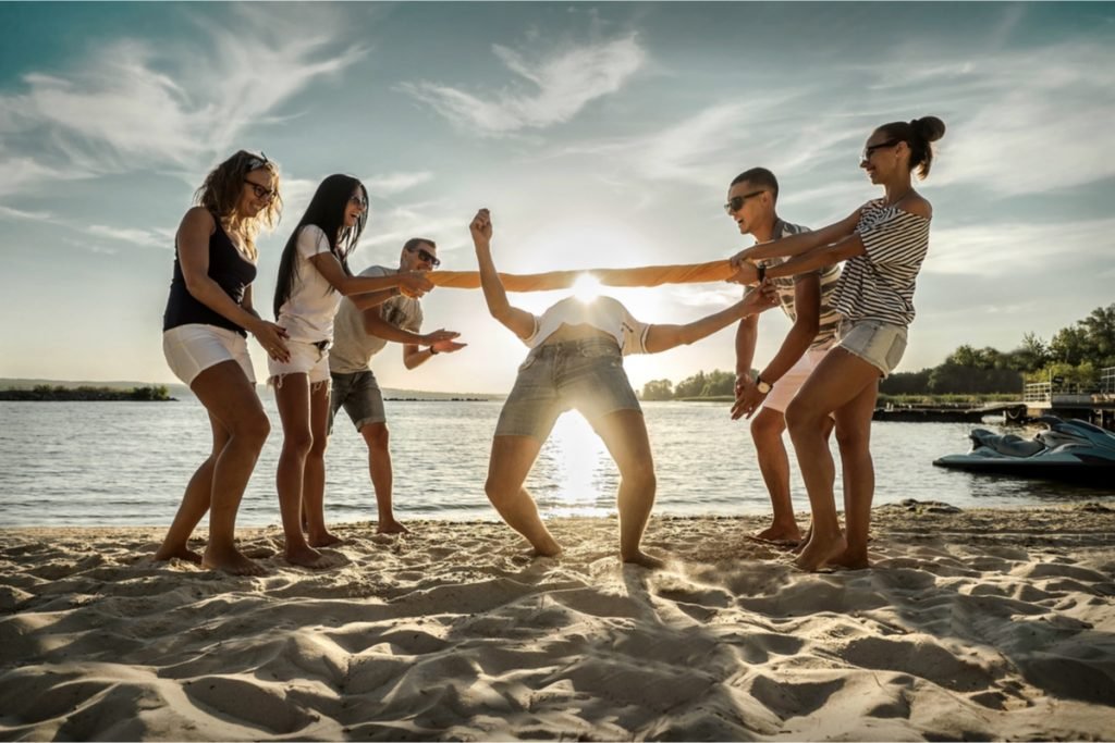 Camping Activities for Adults - Group of Friends With an Impromptu Limbo Game on the Beach