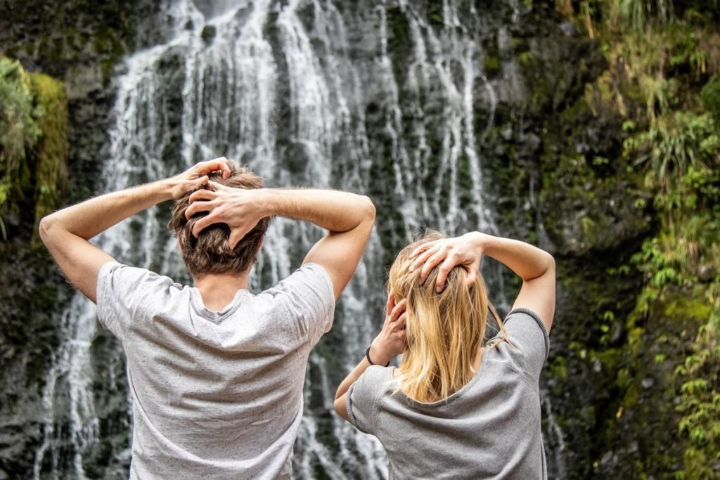 Two people looking in amazement at a waterfall