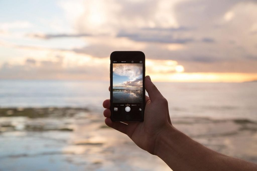 Photograph of a smartphone taking a picter of a beautiful lakeside scene